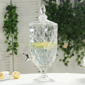 Decorative glass beverage dispenser with lemon slices and spigot.