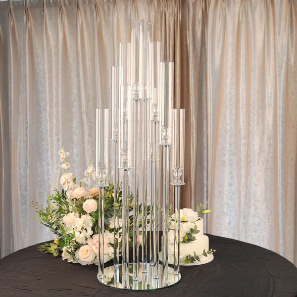 Elegant glass candle holder centerpiece with floral arrangement.