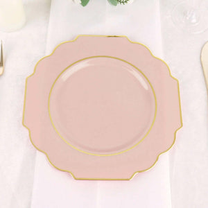 Pink scalloped plate with gold trim on a table setting.