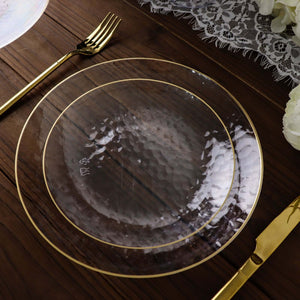 Elegant transparent plate with gold rim on a wooden table.