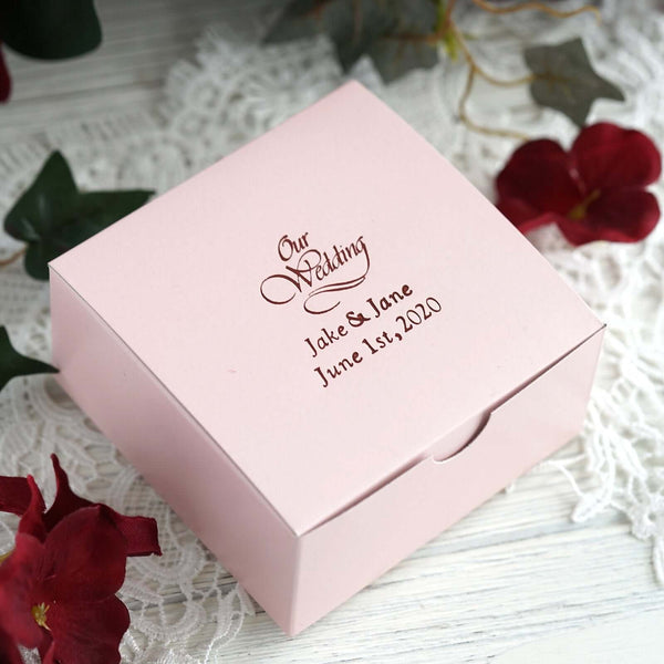 Personalized pink wedding favor box with custom text.