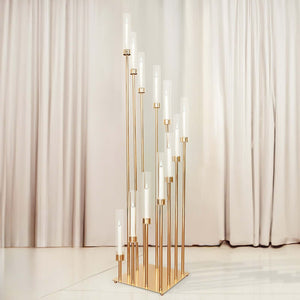 Elegant gold candle holder with multiple glass tubes against a soft backdrop.