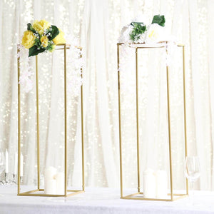 Gold floral display stands with candles and flowers on a sparkling backdrop.