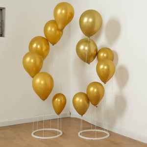 Gold balloons displayed in stylish stands for festive decor. #whtbkgd
