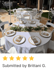 Outdoor table setting by Brittani G with tablecloth, Jute table runner, plates, cutlery holder, garland, and chairs