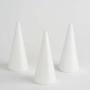 Three white conical crafting foam shapes on a plain background