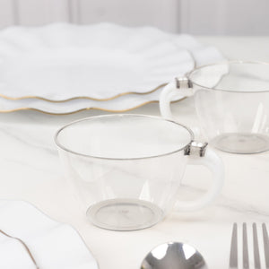 Clear glass teacup with silver rim on a marble surface.