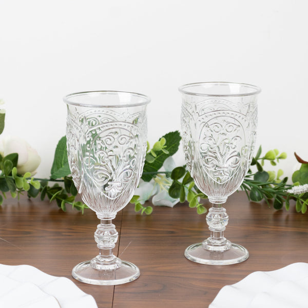 Elegant glass goblets with intricate designs on a wooden table.