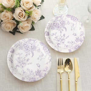 Purple floral patterned dinner plates on a textured tablecloth with cutlery and flowers.