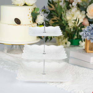 White three-tier serving stand with decorative plates and silver handle