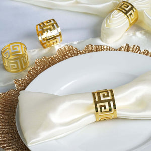 Gold-accented napkin rings on a white plate with elegant decor.