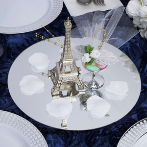 Eiffel Tower centerpiece on a reflective table setting with rose petals.