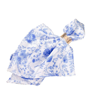 Blue floral patterned scarf with a knot detail on a plain backdrop.