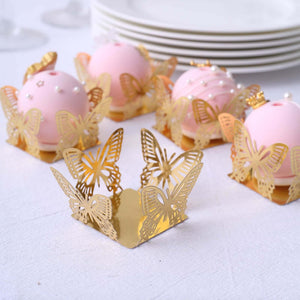 Gold butterfly dessert cups with pink cake balls, elegant party presentation.