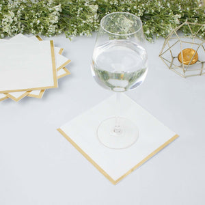 Elegant white coasters with gold trim under a glass of water.