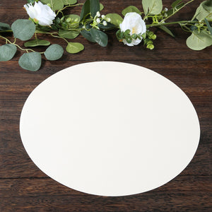 Round beige placemat on wooden surface with greenery accents.