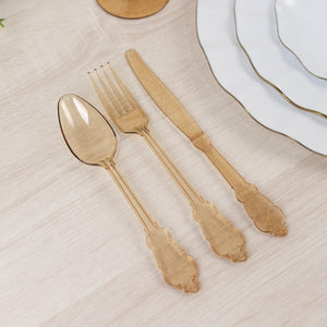 Elegant gold plastic cutlery set on a wooden table.