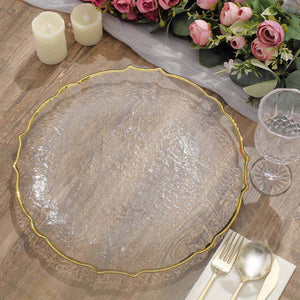 Elegant clear glass charger plate with gold rim on a rustic wooden table.