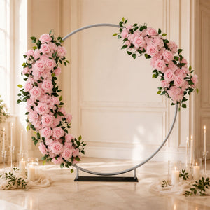 Pink floral wedding arch with roses and candles in elegant indoor venue