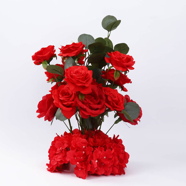 Artificial red rose bouquet with green leaves on white background