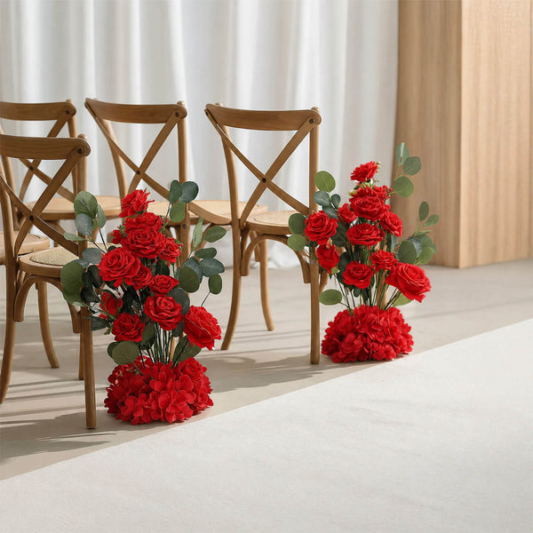 Red rose floral aisle decorations beside wooden chairs in a wedding venue