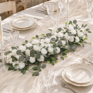 Elegant white floral table centerpiece with gold-rimmed dinnerware and glassware
