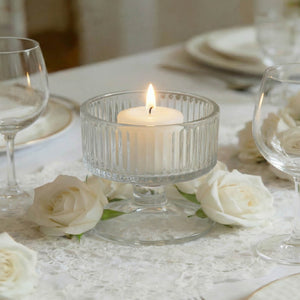 Elegant white candle centerpiece with roses and glassware on a formal table