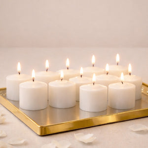 Set of 12 white candles with flames on a gold tray