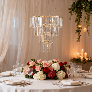 Elegant crystal chandelier above a beautifully arranged table with floral centerpieces.