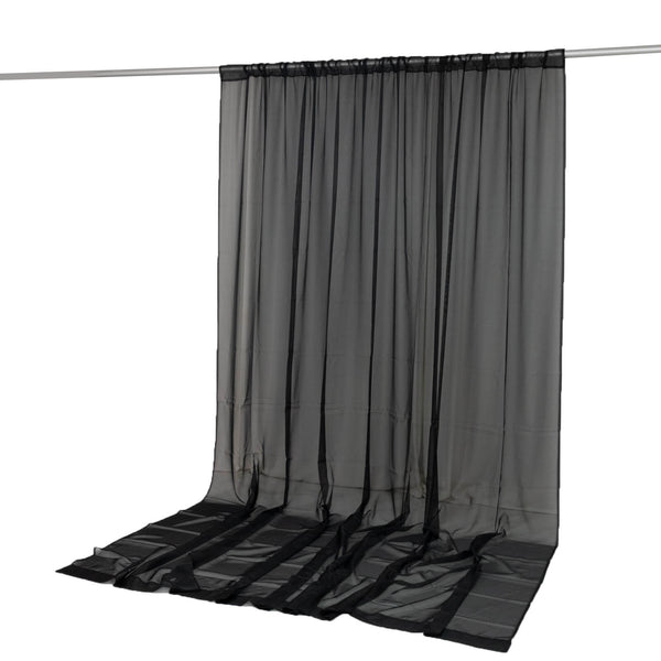 Black sheer curtain panel hanging on a rod, floor-length window treatment