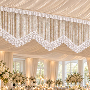 Elegant wedding reception ceiling decor with white draped fabric and crystal chandeliers