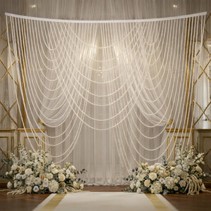 Elegant wedding backdrop with cascading pearls and floral arrangements.