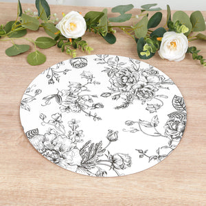 Floral round placemat on a wooden table with greenery and flowers