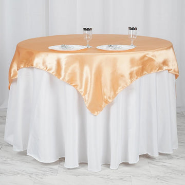 Add a Touch of Glamour to Your Table with our Peach Square Satin Table Overlay