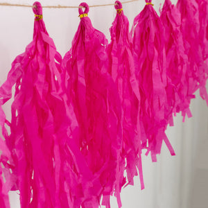 Pink party tassels hanging on a string for festive décor.
