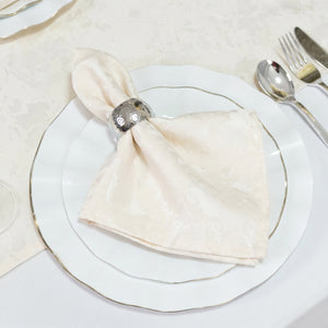 Elegant cream napkin with silver napkin ring on white gold-rimmed table setting