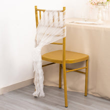 A white wrinkled organza chair sash on a gold chair