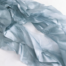 A close up of satin & taffeta chair sashes in blue fabric#whtbkgd