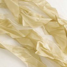 a close up of satin & taffeta chair sashes in gold color#whtbkgd