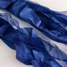 Stylish navy blue curly willow satin and chiffon chair sashes laying on a white surface#whtbkgd