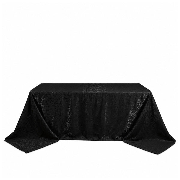 Black satin tablecloth draped over rectangular table on white background