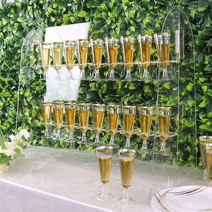 Acrylic champagne tower with glasses filled with golden liquid.