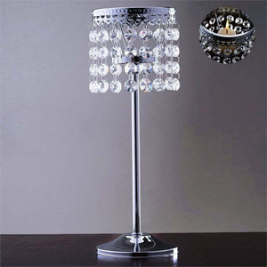 Elegant crystal table lamp with a reflective base and hanging beads.
