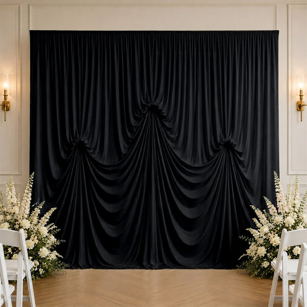Elegant black draped wedding backdrop with white floral arrangements and chairs