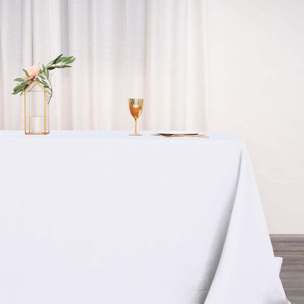 Elegant table setting with a gold glass and floral vase.