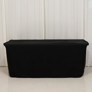Black table cover draped over a table in studio setting.