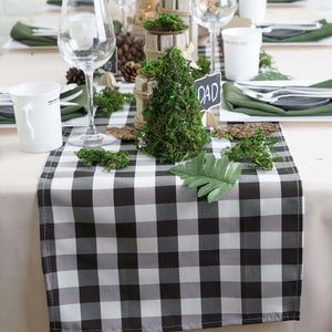 Buffalo check table runner with greenery decor and table setting.