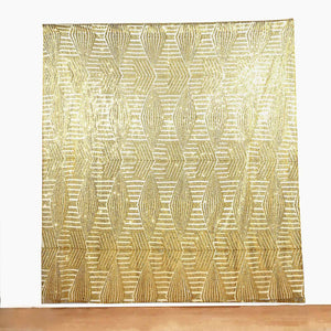 Gold patterned fabric backdrop with geometric design.