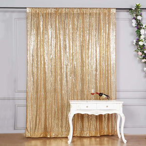 Gold sequin curtain draped elegantly behind a white table with wine and glass.