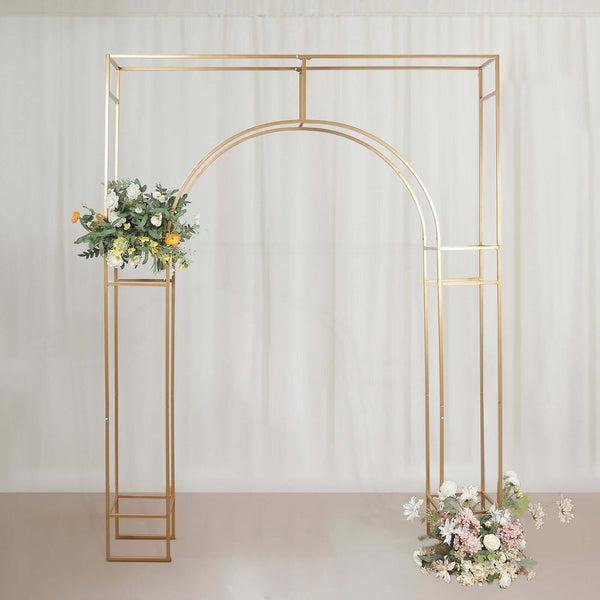 Gold wedding arch with floral arrangements on a soft backdrop.